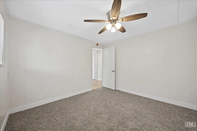 a view of an empty room with a chandelier fan