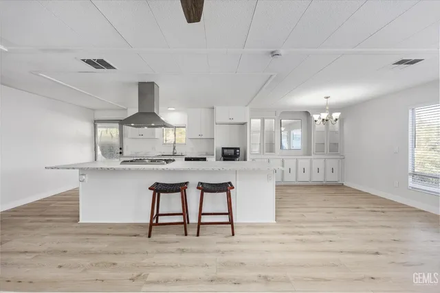a kitchen with stainless steel appliances granite countertop a white cabinets and wooden floor