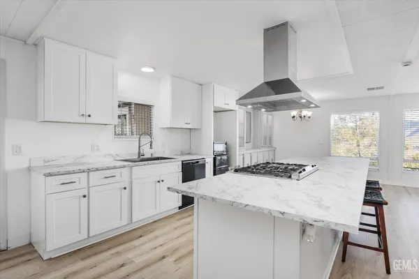 a kitchen with granite countertop a sink a stove and cabinets