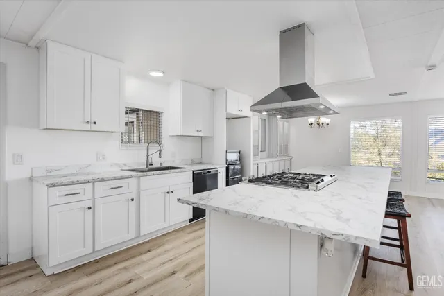 a kitchen with granite countertop a sink a stove and cabinets