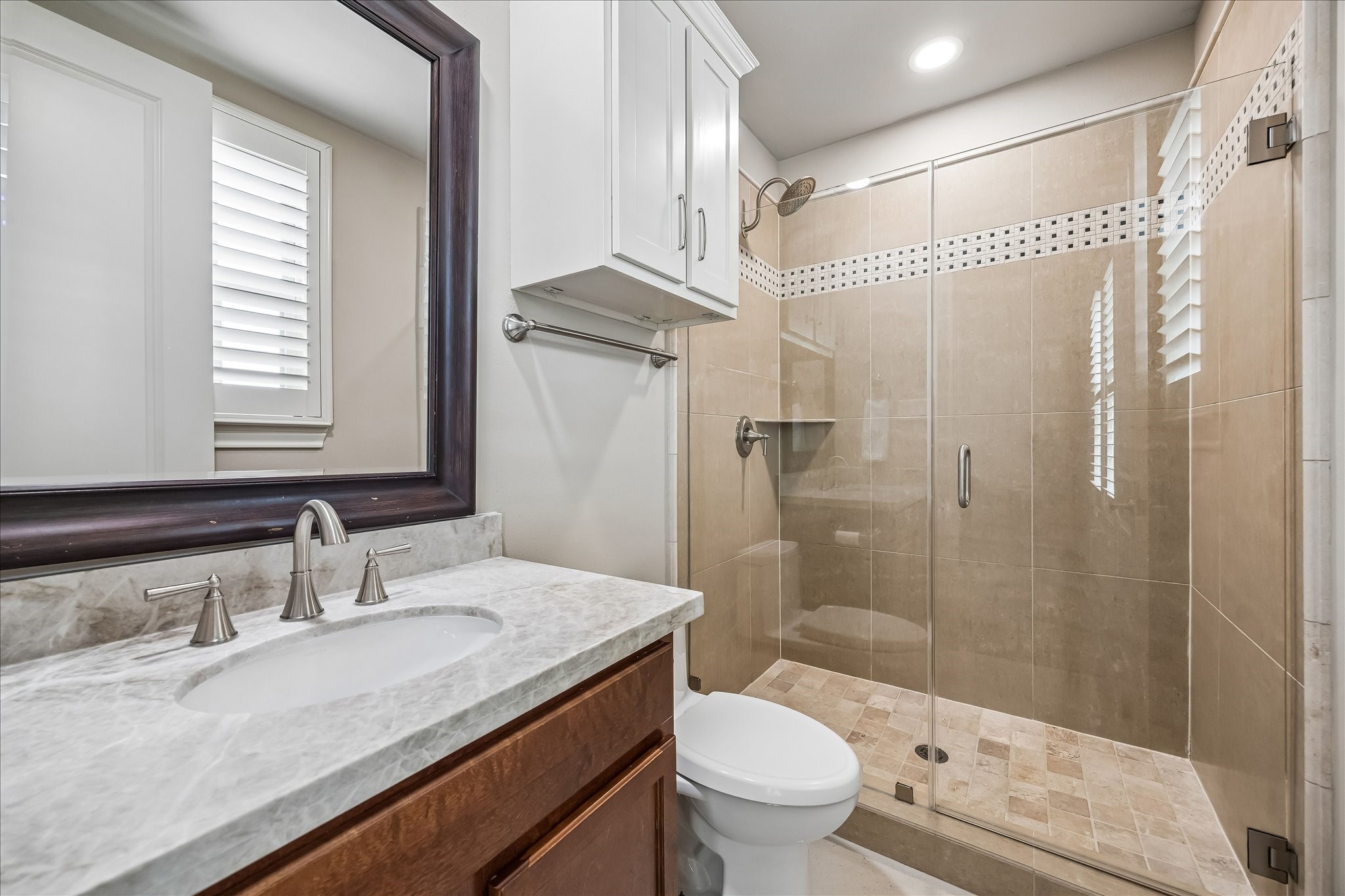 907 Queen Annes Road Houston, TX 77024 - Photo 17 of 31 Well-appointed secondary bath featuring Taj Mahal quartzite countertops, glass-enclosed shower, and timeless neutral finishes.