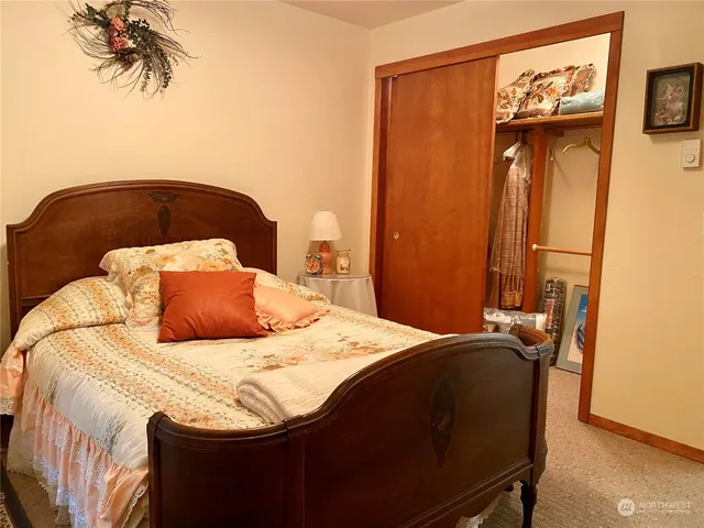 a bedroom with a bed and a painting on the wall