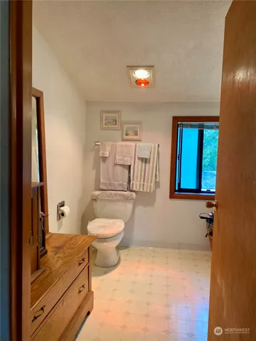 a bathroom with a toilet a sink and mirror