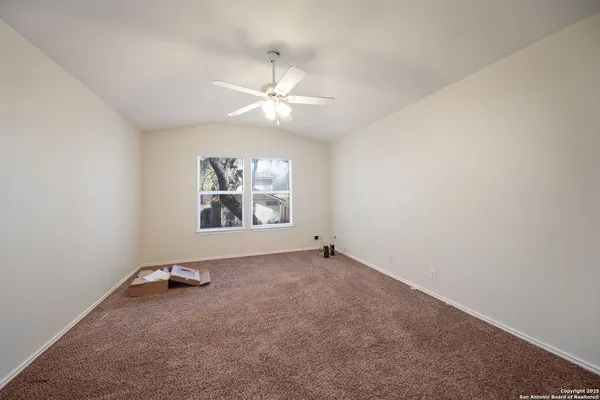 an empty room with windows and fan