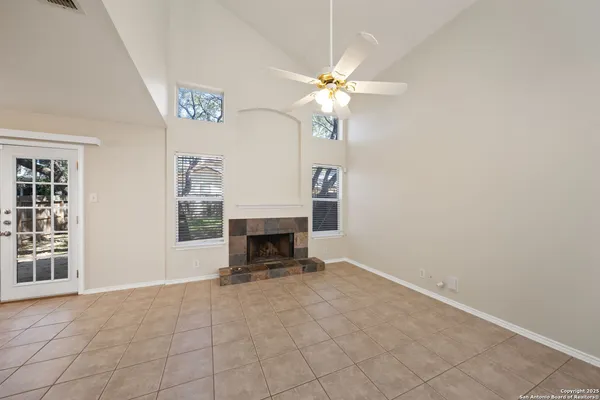 an empty room with windows and fireplace