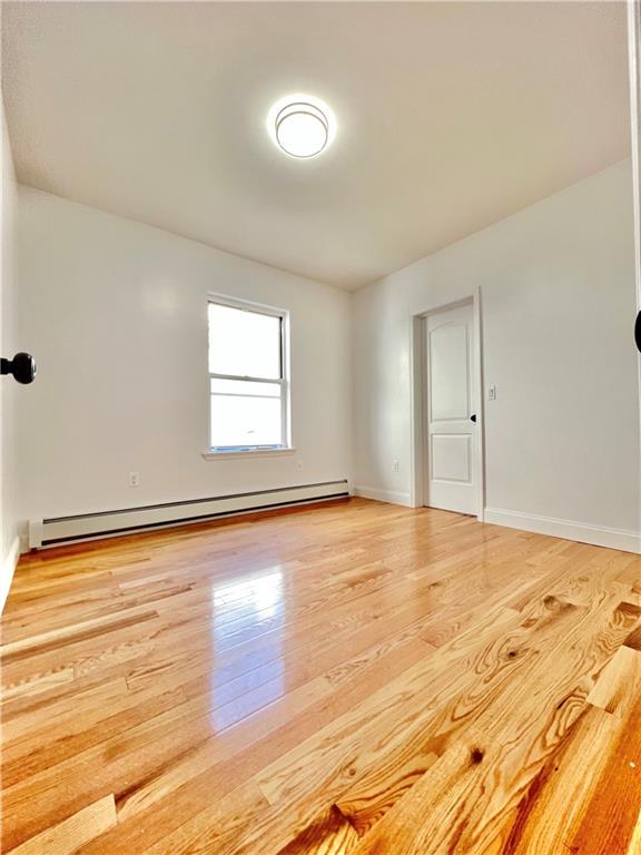 1651 85th Street Brooklyn, NY 11214 - Photo 4 of 17 an empty room with wooden floor and windows
