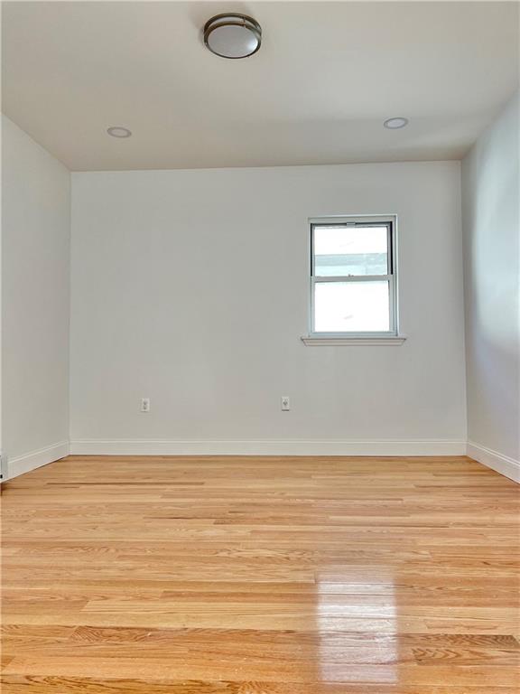 1651 85th Street Brooklyn, NY 11214 - Photo 7 of 17 a view of an empty room with wooden floor and windows
