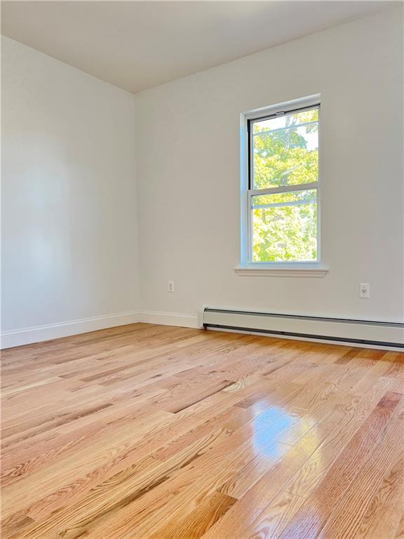 1651 85th Street Brooklyn, NY 11214 - Photo 9 of 17 an empty room with wooden floor and windows