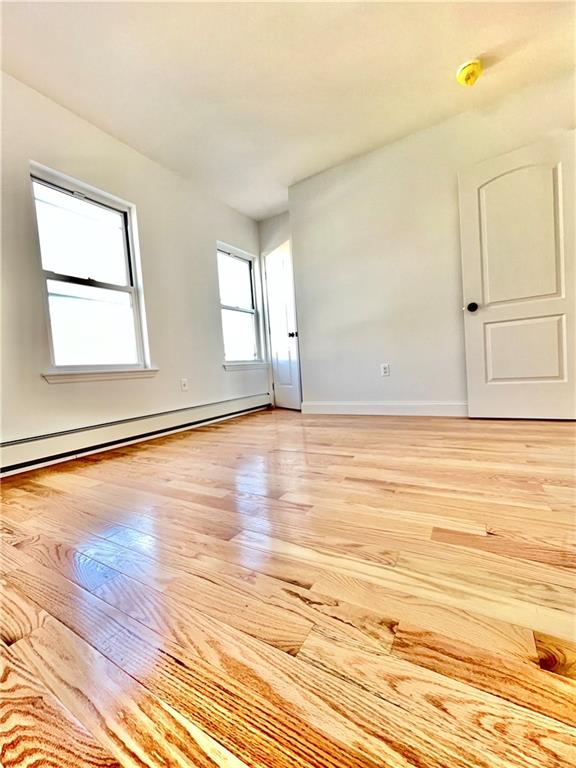 1651 85th Street Brooklyn, NY 11214 - Photo 10 of 17 a view of an empty room with wooden floor and a window