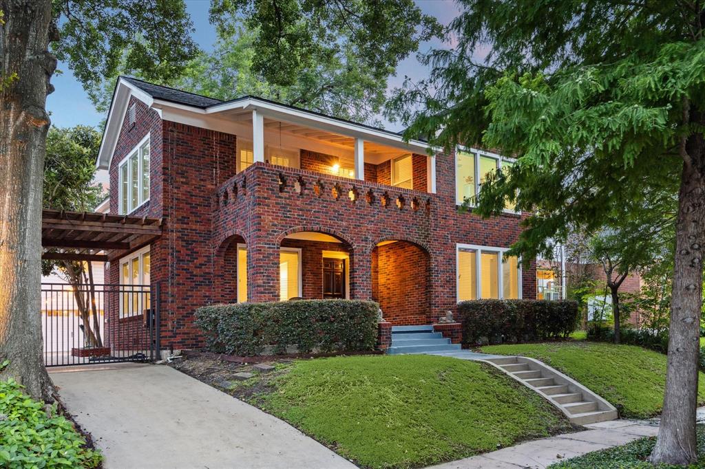 Nestled above a lovely tree-lined street, this handsome 2,717-square-foot brick home + 700 SF garage apartment impresses with a charming brick façade and inviting covered porches.