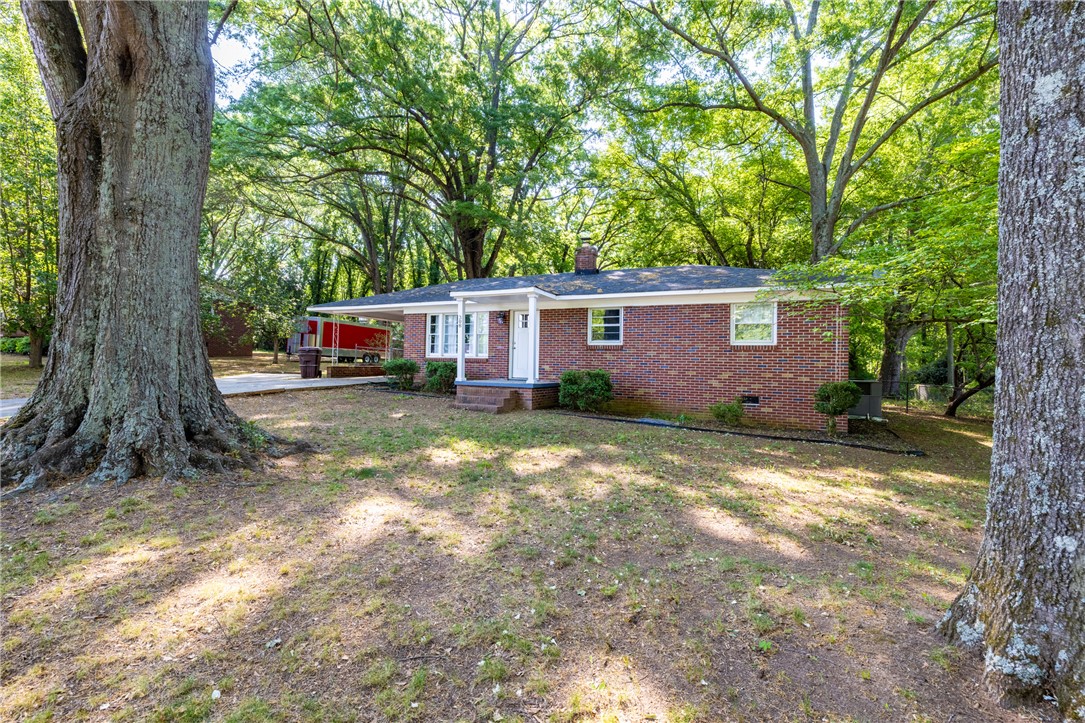 308 Buchanan Circle Pendleton, SC 29670 - Photo 2 of 19 This classic brick residence is nestled amidst mature trees, offering a serene and private setting.
