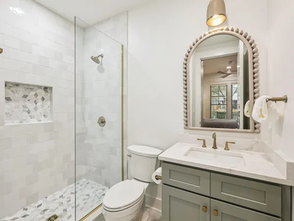 a bathroom with a sink a toilet and shower