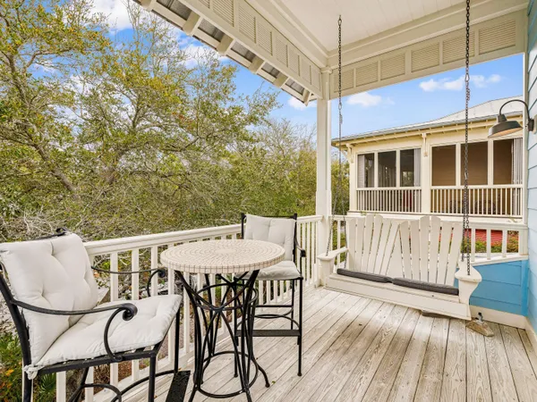 a view of a patio with table and chairs with wooden floor and fence