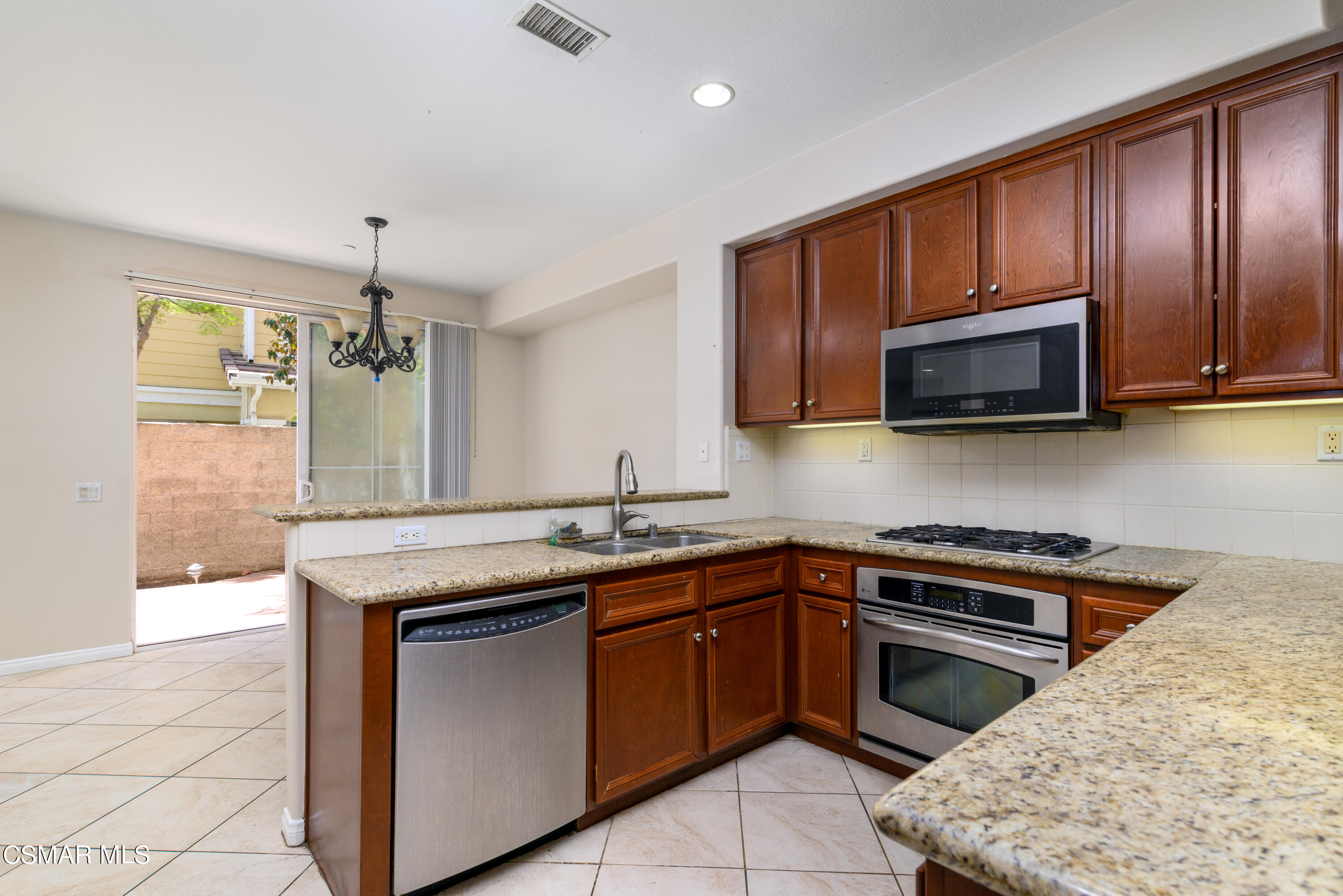 4120 Paredo Way, Unit C Simi Valley, CA 93063 - Photo 7 of 24 a kitchen with stainless steel appliances granite countertop wooden cabinets a stove top oven a sink and dishwasher