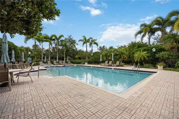 a view of a swimming pool with a patio and a lake view