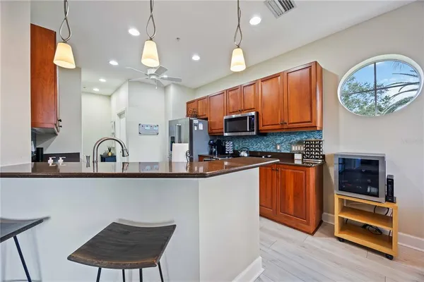 a kitchen with stainless steel appliances granite countertop a sink a stove a microwave a refrigerator and cabinets