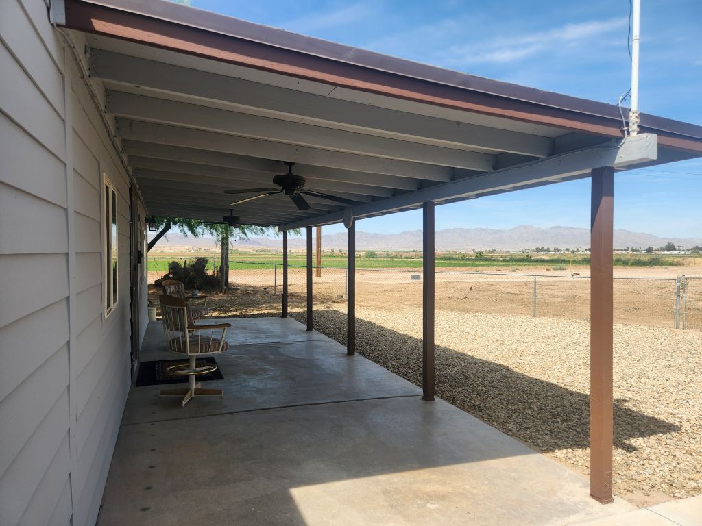 8257 Green Valley Road Mohave Valley, AZ 86440 - Photo 11 of 41 Expansive covered patio featuring a concrete surface, multiple ceiling fans, and a gravel perimeter