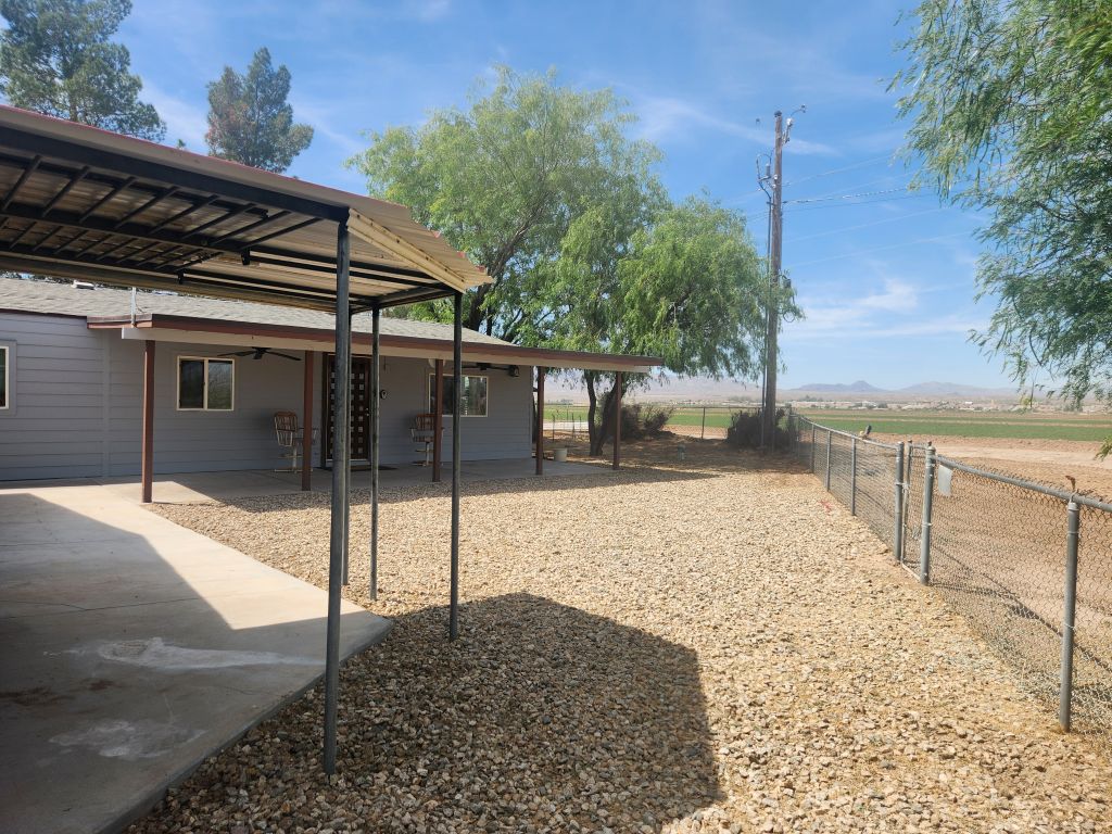 8257 Green Valley Road Mohave Valley, AZ 86440 - Photo 12 of 41 Gravel-covered yard with a concrete walkway and an attached covered carport structure
