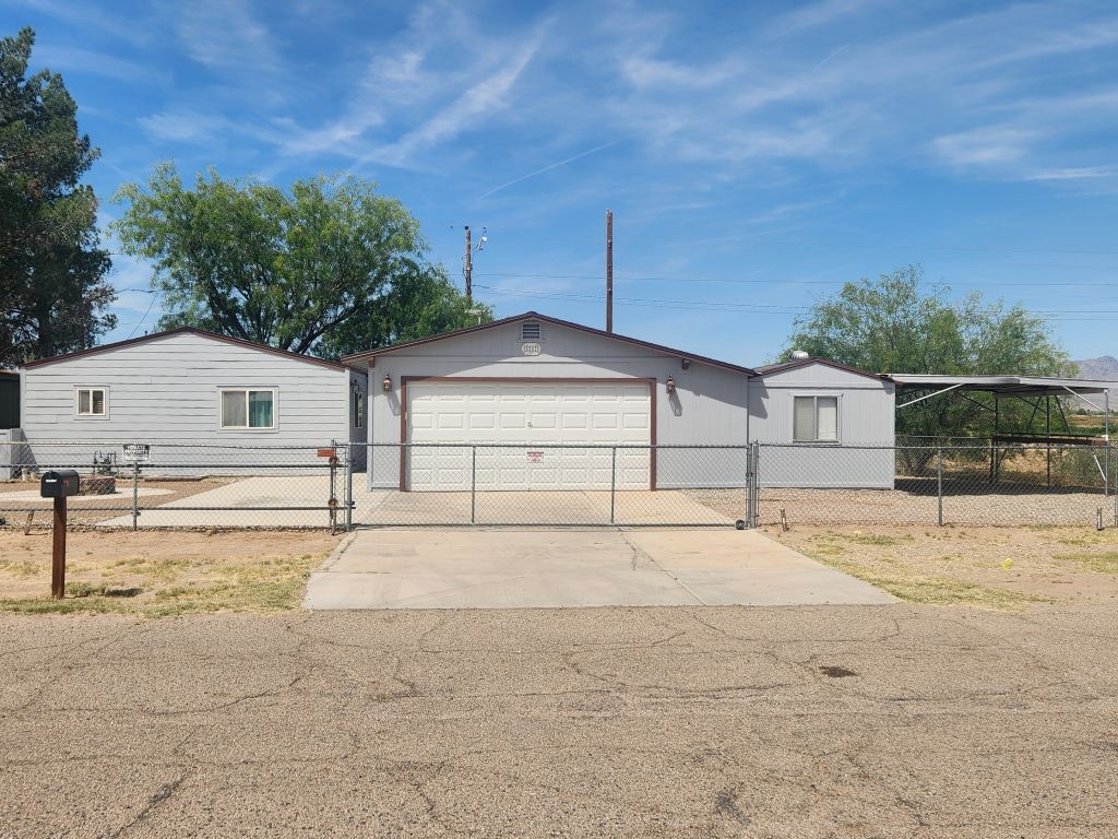8257 Green Valley Road Mohave Valley, AZ 86440 - Photo 2 of 41 Fenced property featuring a central garage, a concrete driveway, attached covered carport and chain-link fencing with roll gate and double gate entry