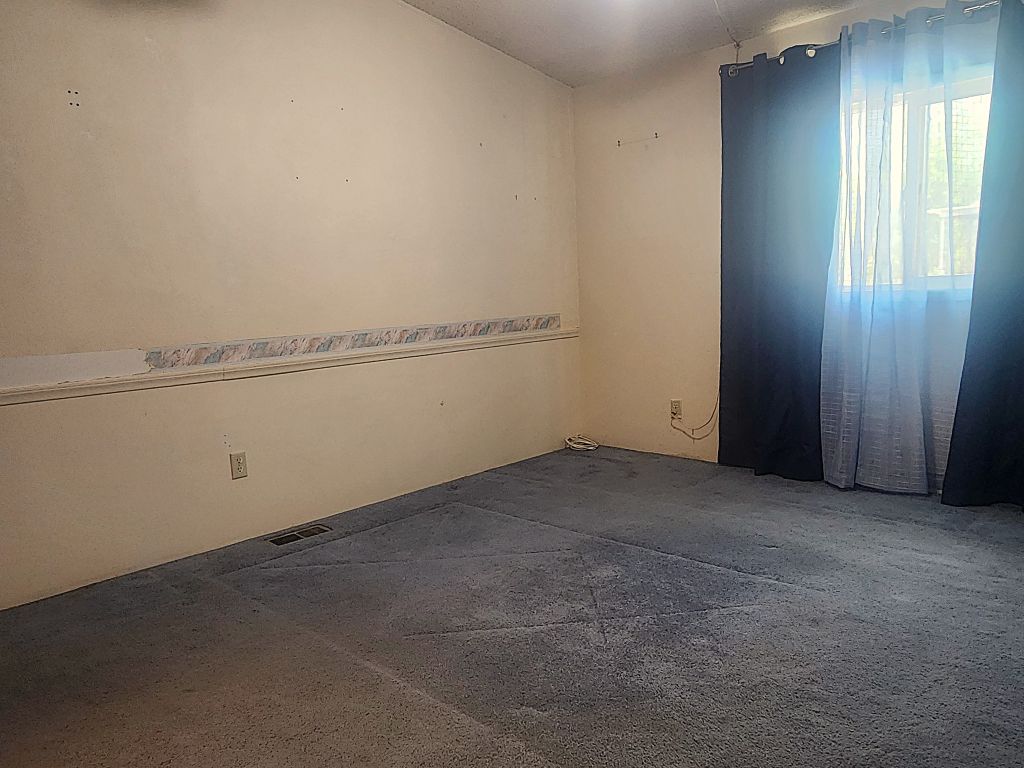 8257 Green Valley Road Mohave Valley, AZ 86440 - Photo 22 of 41 Carpeted room featuring a window with privacy curtains, light-toned walls, and baseboard???????????????????????????????? trim