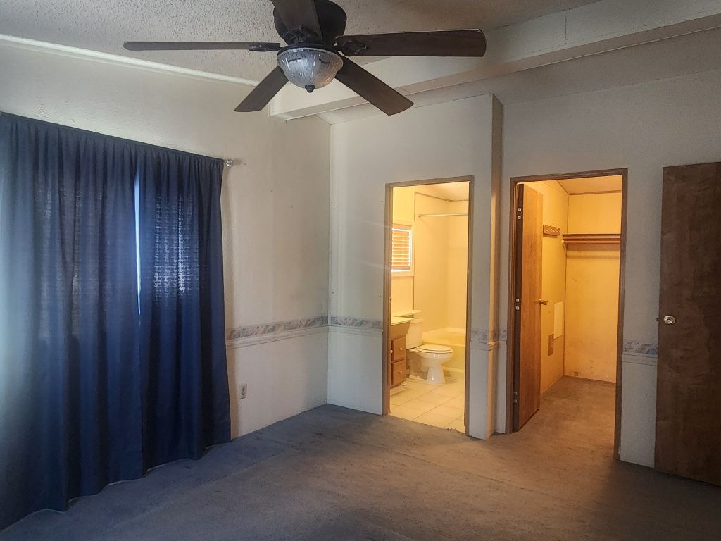 8257 Green Valley Road Mohave Valley, AZ 86440 - Photo 23 of 41 Carpeted room featuring a ceiling fan, a full bathroom, and a walk-in closet