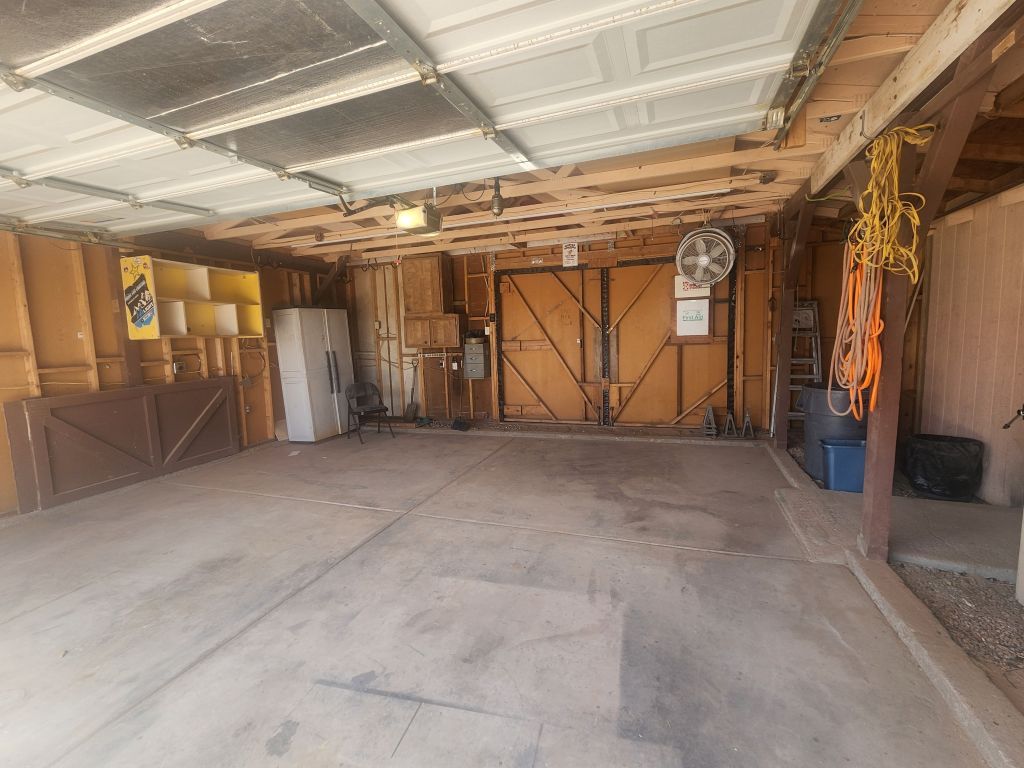 8257 Green Valley Road Mohave Valley, AZ 86440 - Photo 31 of 41 Garage featuring pass-through door, concrete slab flooring with exposed wood framing
