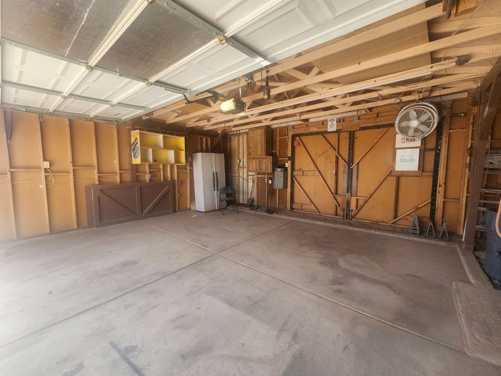 8257 Green Valley Road Mohave Valley, AZ 86440 - Photo 33 of 41 Garage featuring pass-through door, mounted fan, concrete flooring and exposed ceiling joists