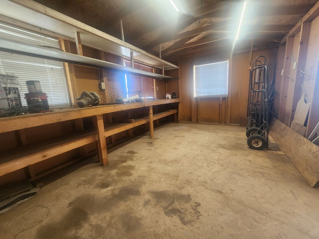 8257 Green Valley Road Mohave Valley, AZ 86440 - Photo 34 of 41 Workshop space featuring concrete flooring, exposed wood framing, and built-in shelving