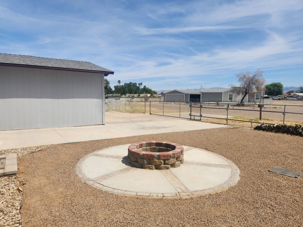 8257 Green Valley Road Mohave Valley, AZ 86440 - Photo 7 of 41 Outdoor fire pit with a circular concrete pad, surrounded by gravel landscaping