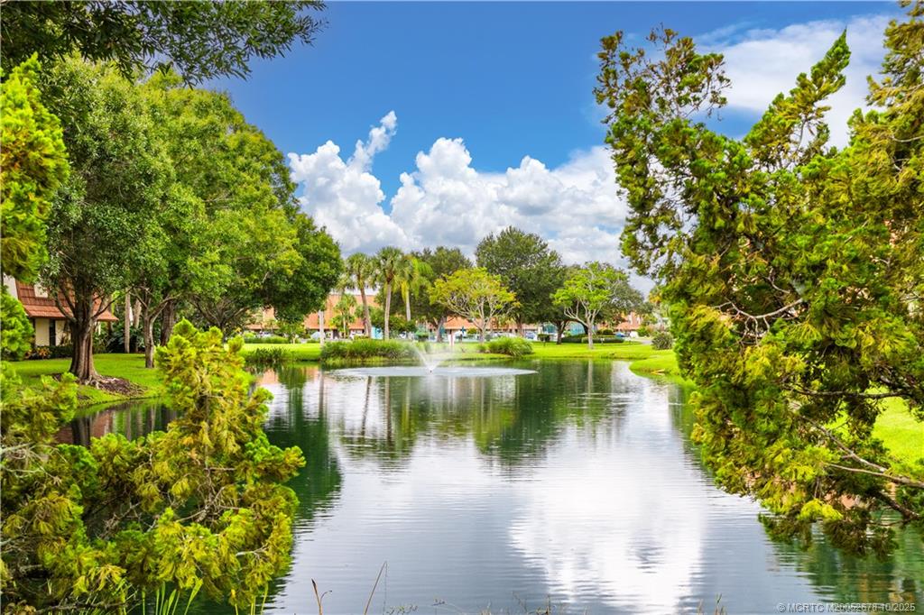 3100 Southeast Pruitt Road, Unit B301 Port St. Lucie, FL 34952 - Photo 20 of 48 a view of a lake with a house in the background