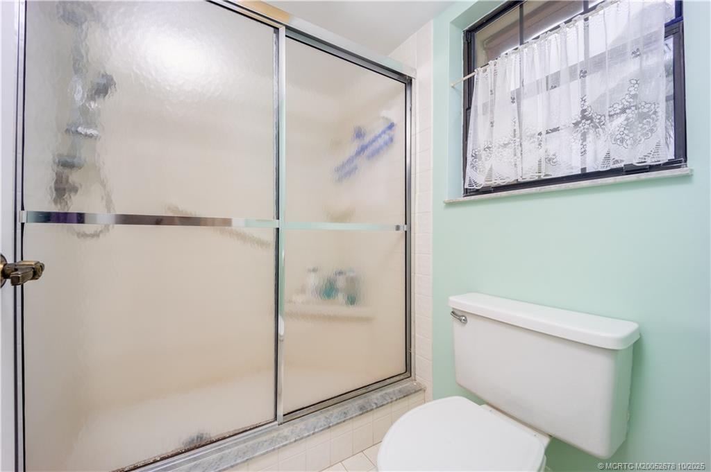3100 Southeast Pruitt Road, Unit B301 Port St. Lucie, FL 34952 - Photo 23 of 48 a white toilet sitting next to a bathroom shower