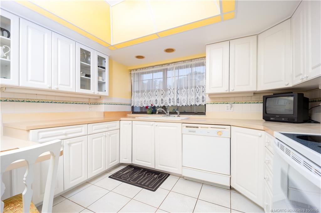 3100 Southeast Pruitt Road, Unit B301 Port St. Lucie, FL 34952 - Photo 30 of 48 a kitchen with granite countertop white cabinets and white appliances