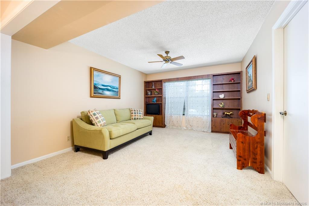 3100 Southeast Pruitt Road, Unit B301 Port St. Lucie, FL 34952 - Photo 32 of 48 a living room with furniture and a flat screen tv