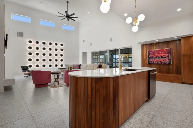 a kitchen with a chandelier stainless steel appliances a sink dishwasher and cabinets