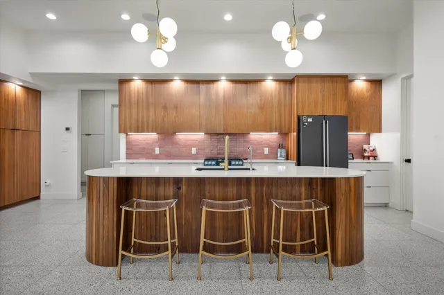 a kitchen with a table chairs refrigerator and microwave