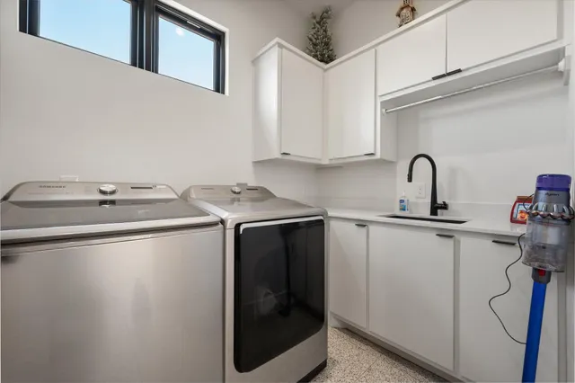 a utility room with sink dryer and washer