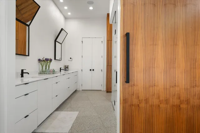 a spacious bathroom with 2 sink and a mirror