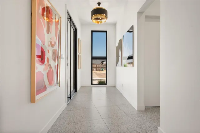 a view of a hallway with entryway with wooden floor