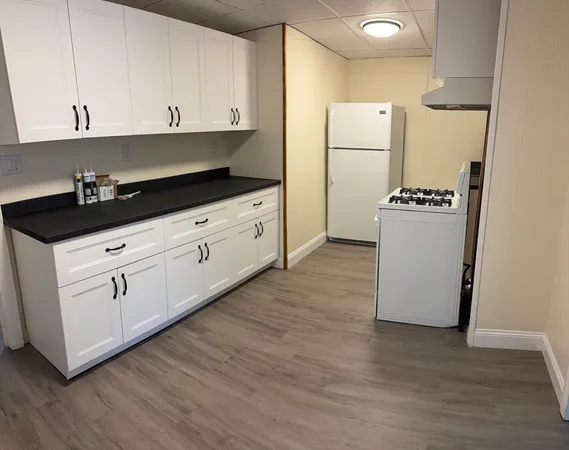 a kitchen with granite countertop white cabinets and white appliances