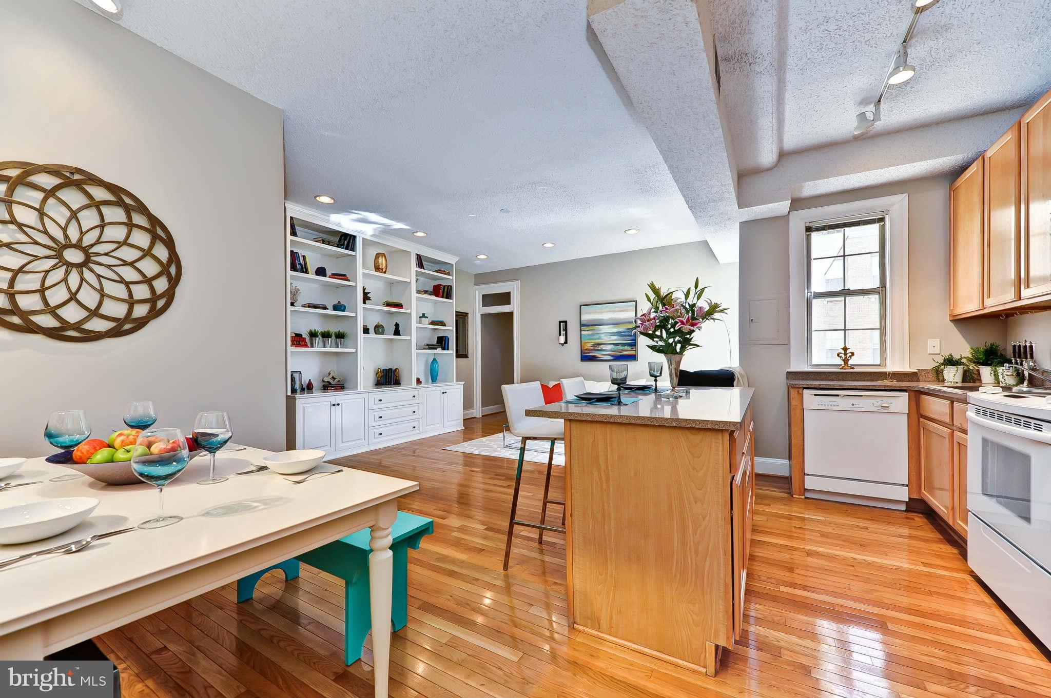 1401 Columbia Road Northwest, Unit 302 Washington, DC 20009 - Photo 13 of 30 a kitchen with granite countertop a table chairs stove and cabinets