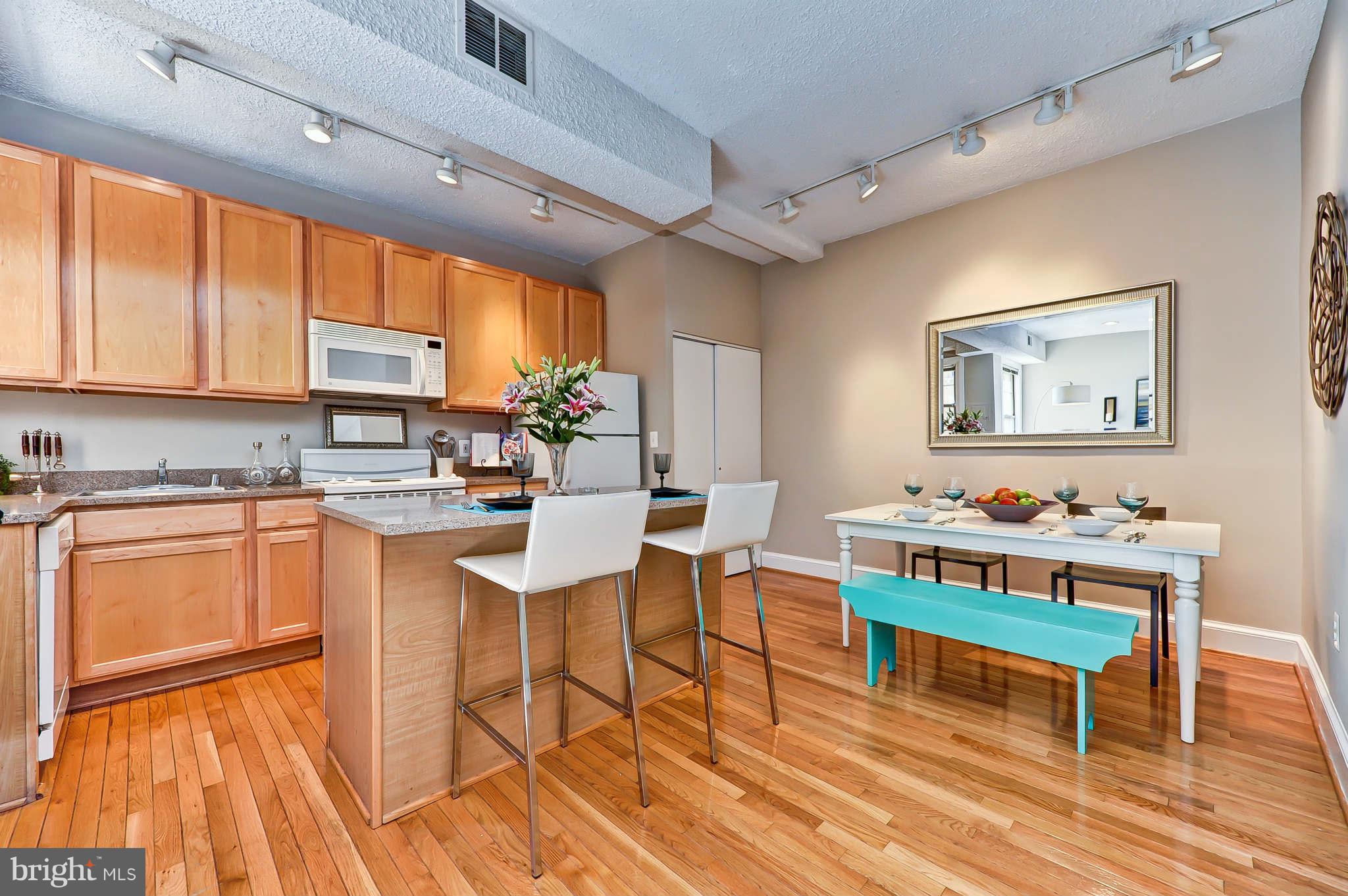 1401 Columbia Road Northwest, Unit 302 Washington, DC 20009 - Photo 15 of 30 a kitchen with a cabinets and chairs in it