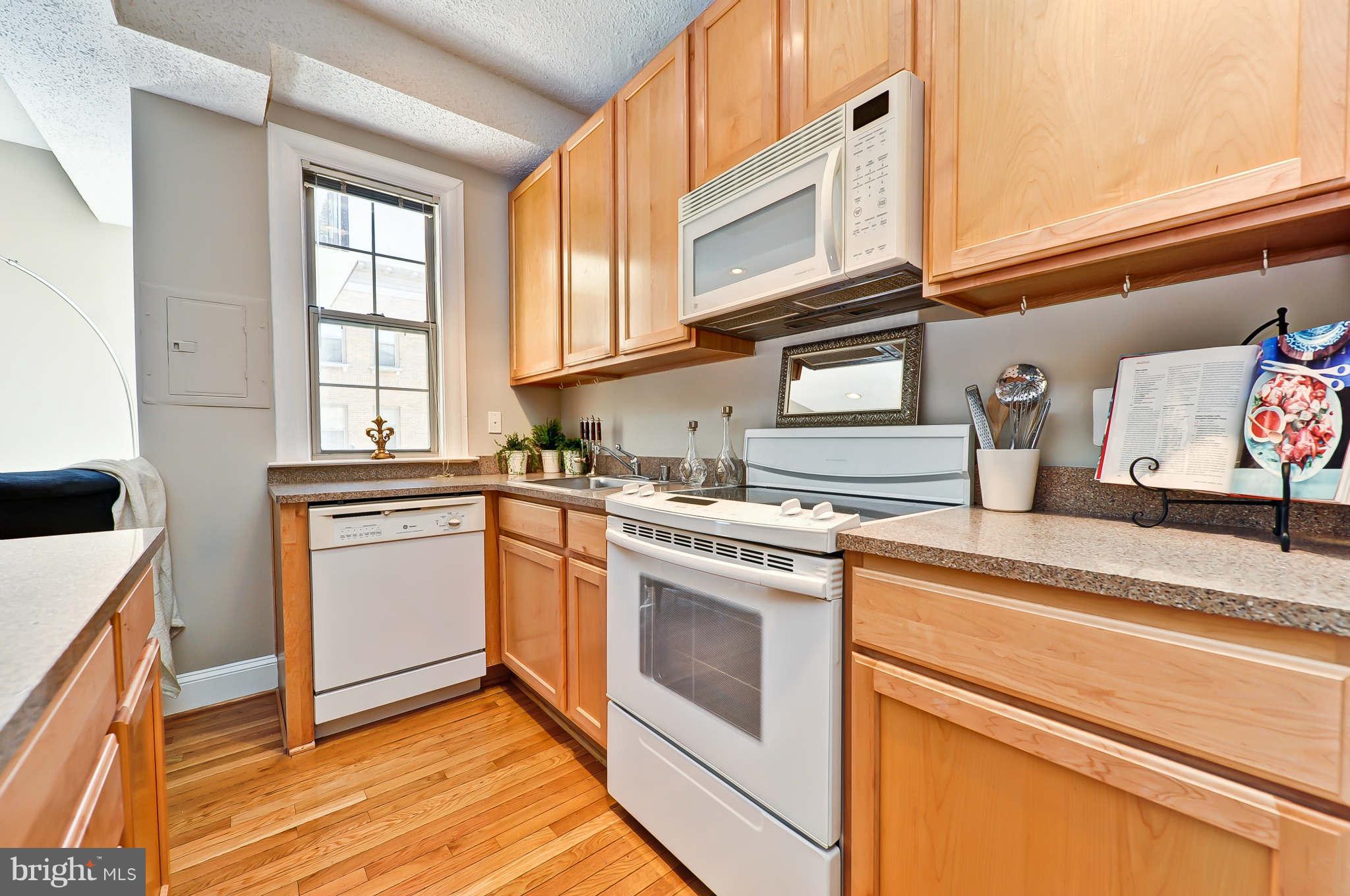 1401 Columbia Road Northwest, Unit 302 Washington, DC 20009 - Photo 19 of 30 a kitchen with stainless steel appliances granite countertop a sink and a stove