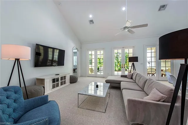 a living room with furniture flat screen tv and a large window