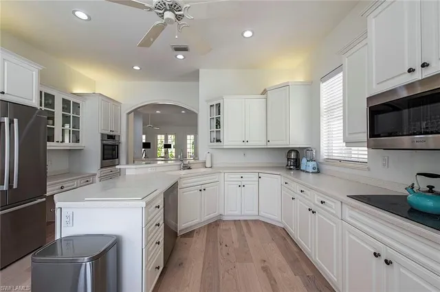 a kitchen with granite countertop a sink stainless steel appliances and white cabinets
