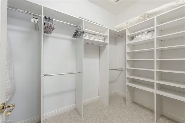 a view of walk in closet with empty racks