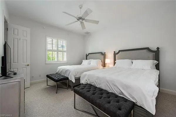 a bedroom with two beds and a flat screen tv