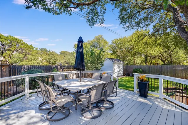 a view of deck with furniture and trees