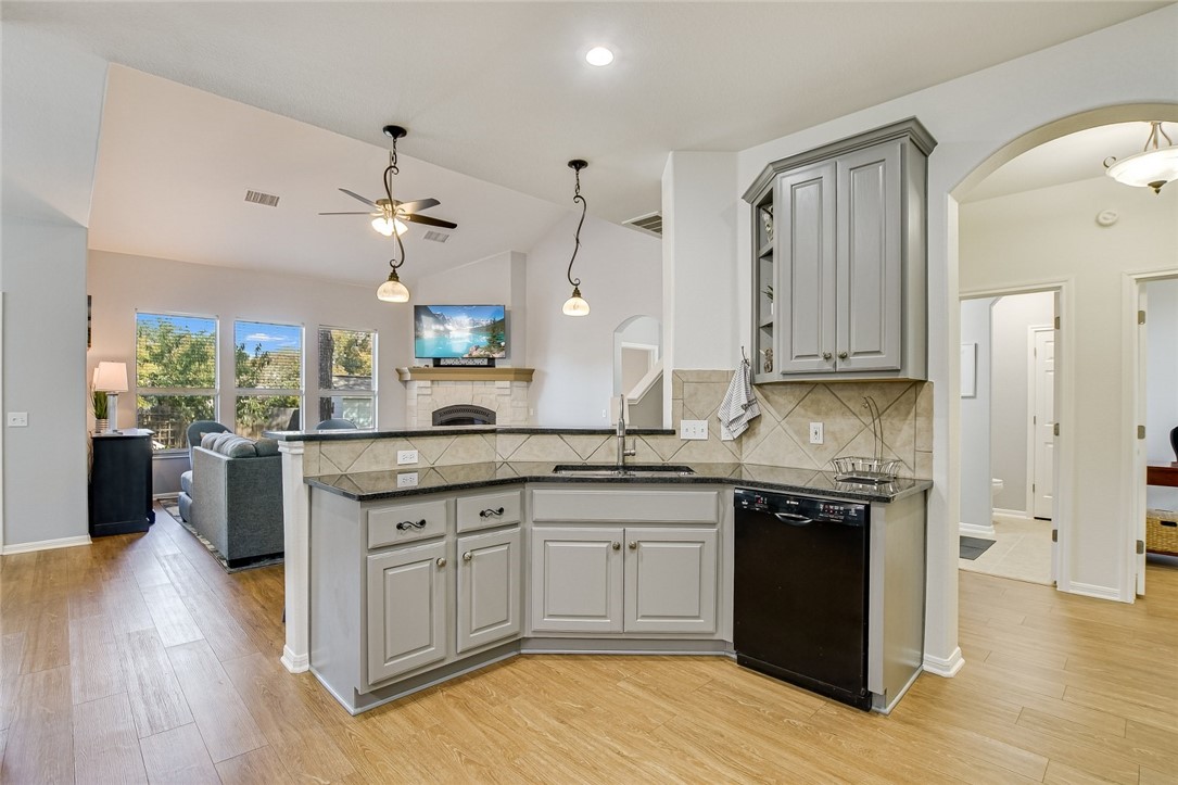 6405 York Bridge Circle Austin, TX 78749 - Photo 10 of 34 a kitchen with granite countertop a sink cabinets and wooden floor