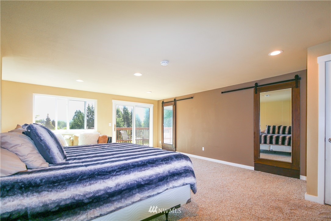 27615 Webster Road East Graham, WA 98338 - Photo 14 of 36 a bedroom with a bed and glass walk in closet