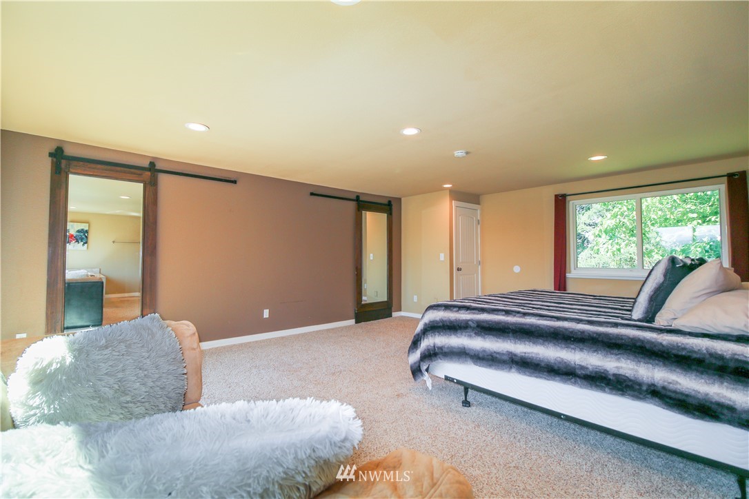 27615 Webster Road East Graham, WA 98338 - Photo 15 of 36 a spacious bedroom with a large bed and a couch
